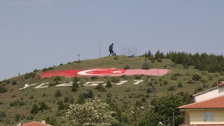 Yozgat’ta bir vatandaş, tepenin yamacındaki rengi solan dev Türk bayrağını boyuyor